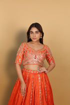 Orange box-pleated lehenga with a heavily worked blouse and dupatta