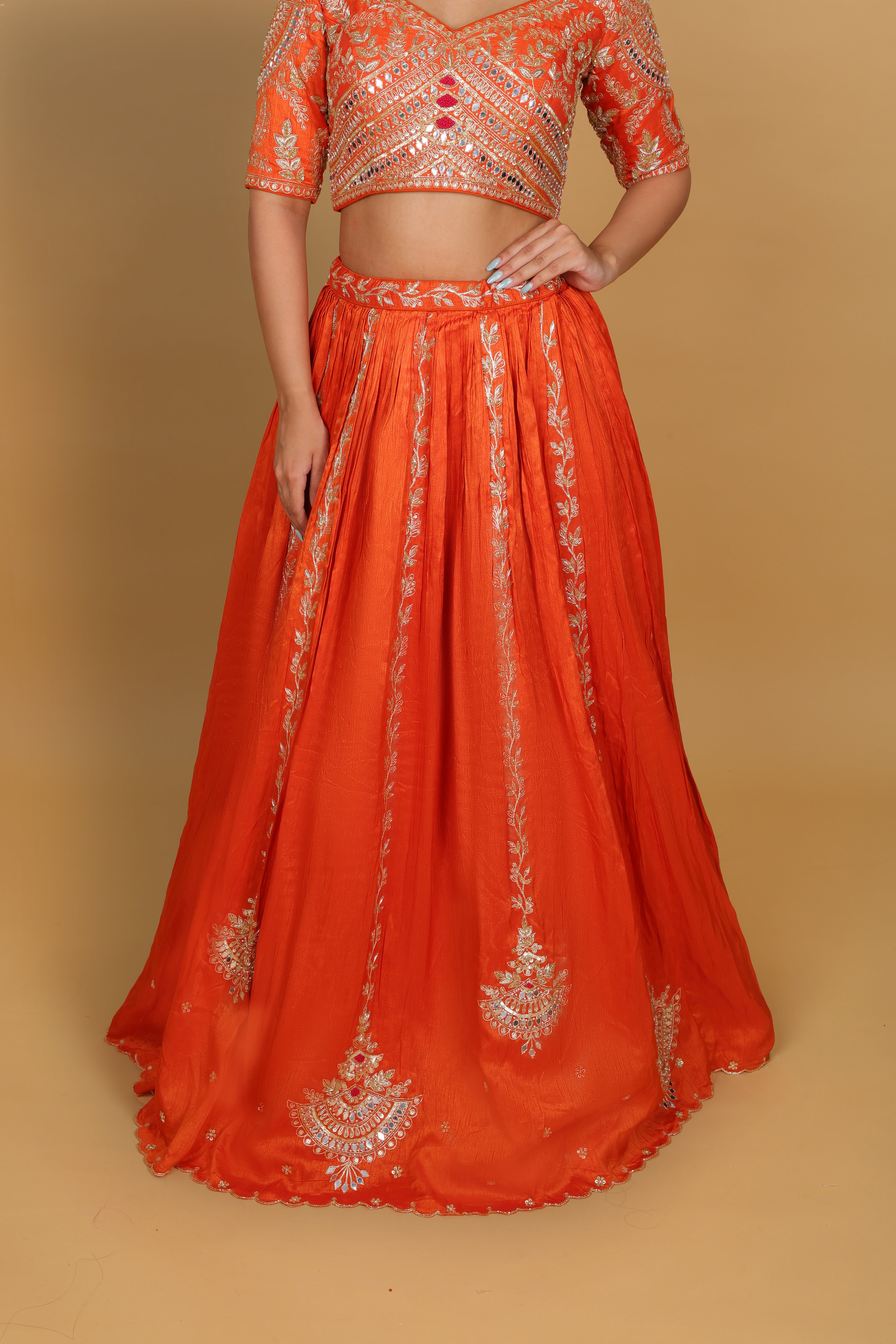 Orange box-pleated lehenga with a heavily worked blouse and dupatta