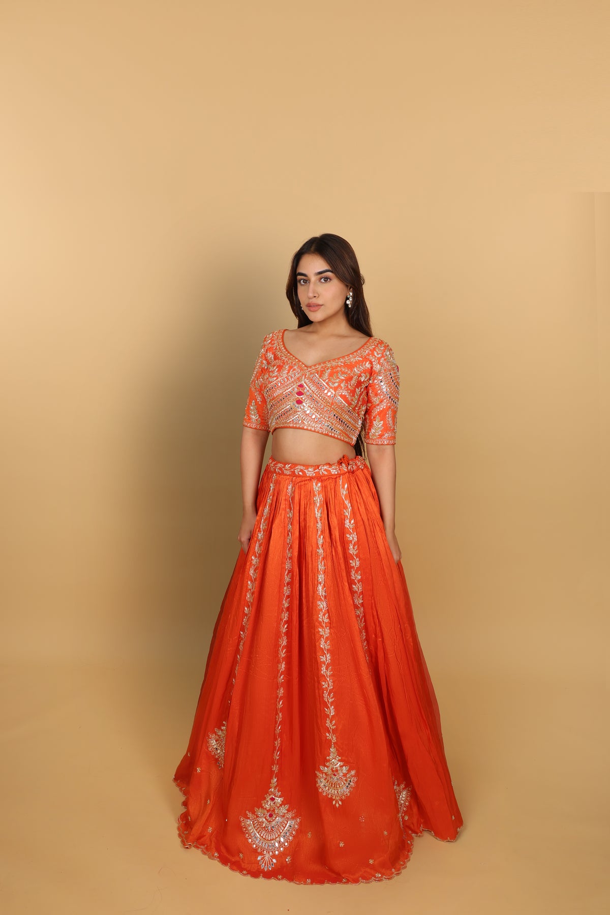 Orange box-pleated lehenga with a heavily worked blouse and dupatta