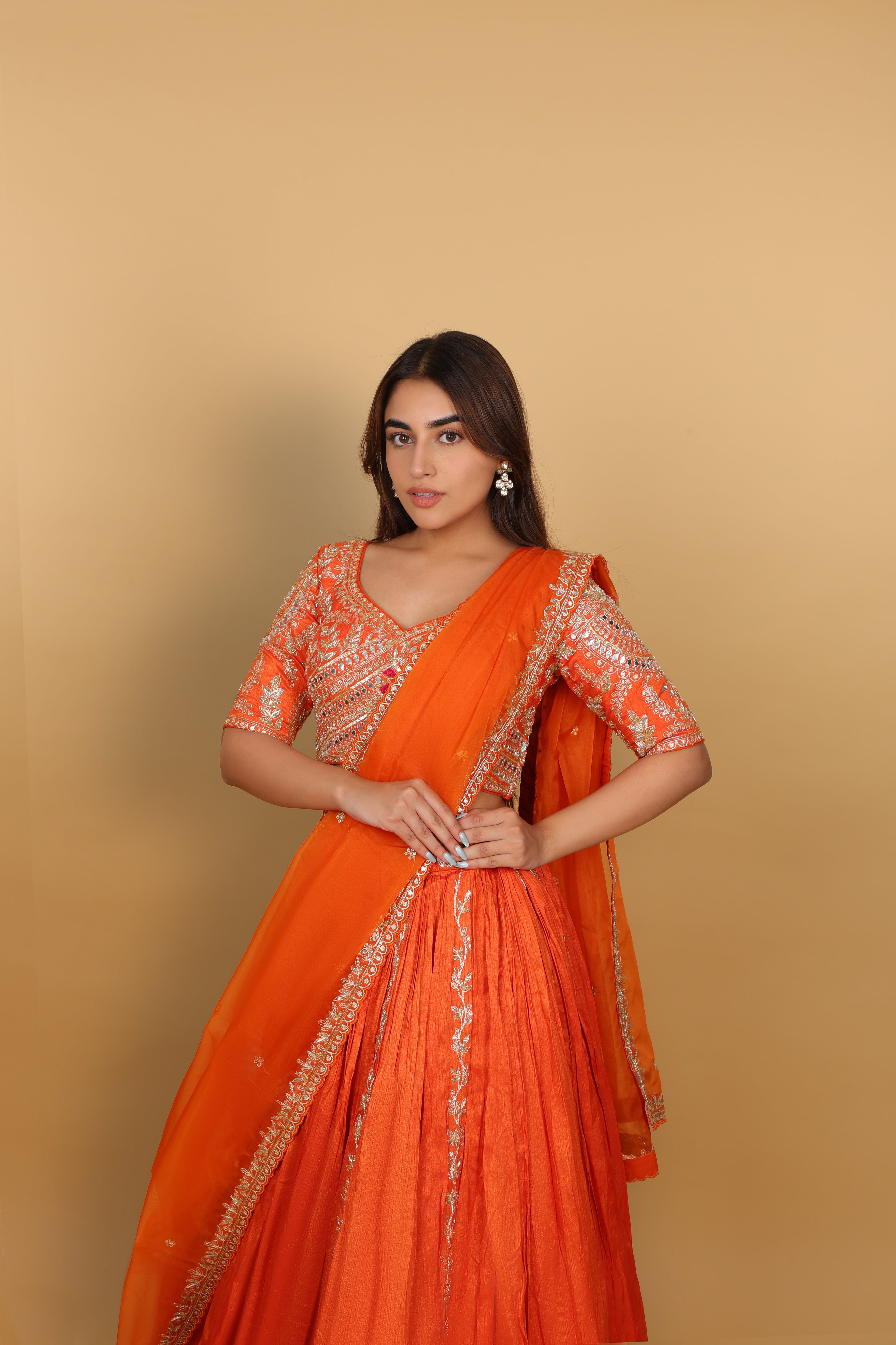 Orange box-pleated lehenga with a heavily worked blouse and dupatta
