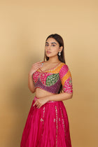 Magenta/Rani lehenga with a heavily worked multicoloured blouse and dupatta