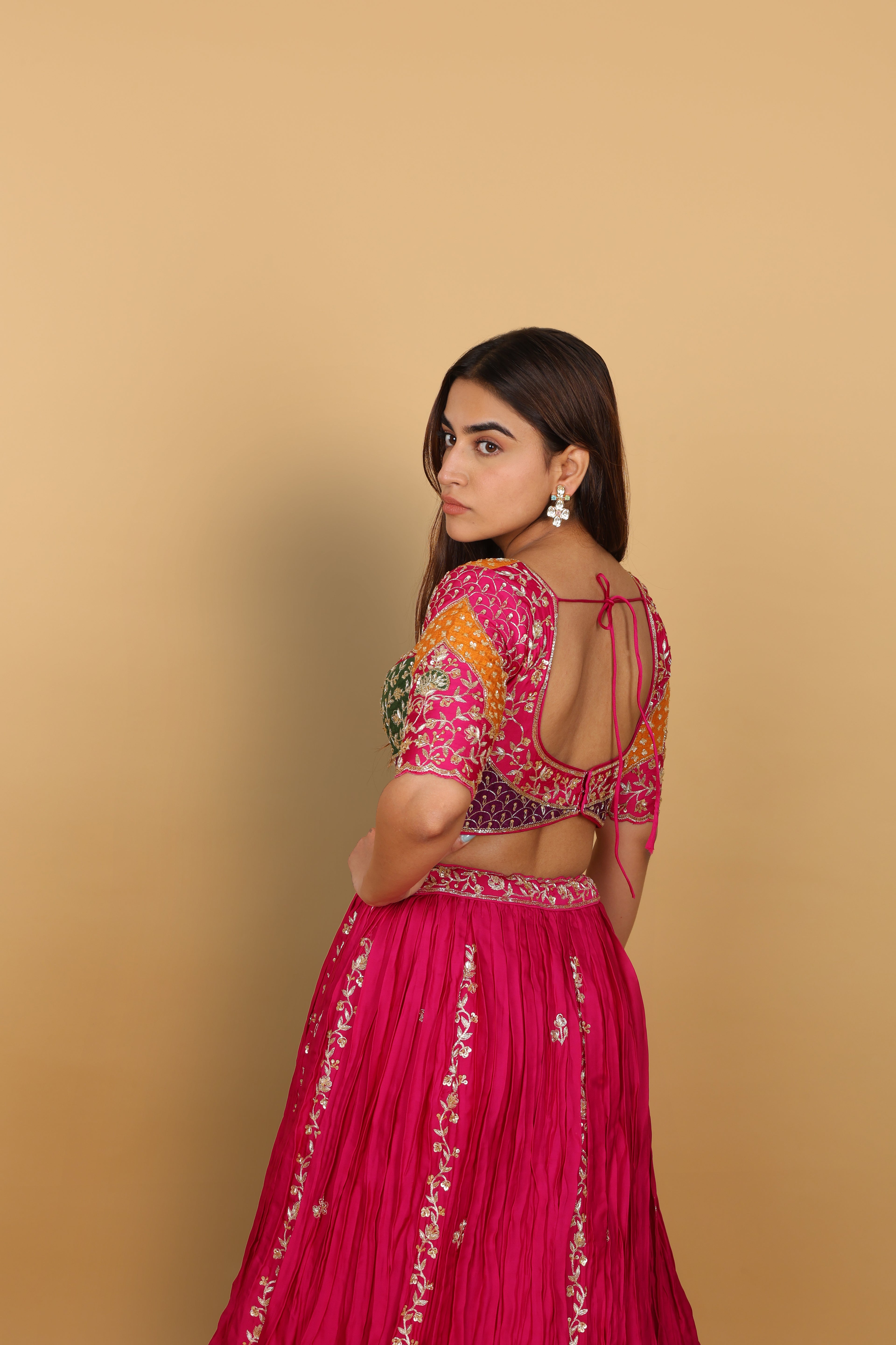 Magenta/Rani lehenga with a heavily worked multicoloured blouse and dupatta