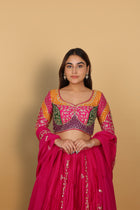 Magenta/Rani lehenga with a heavily worked multicoloured blouse and dupatta