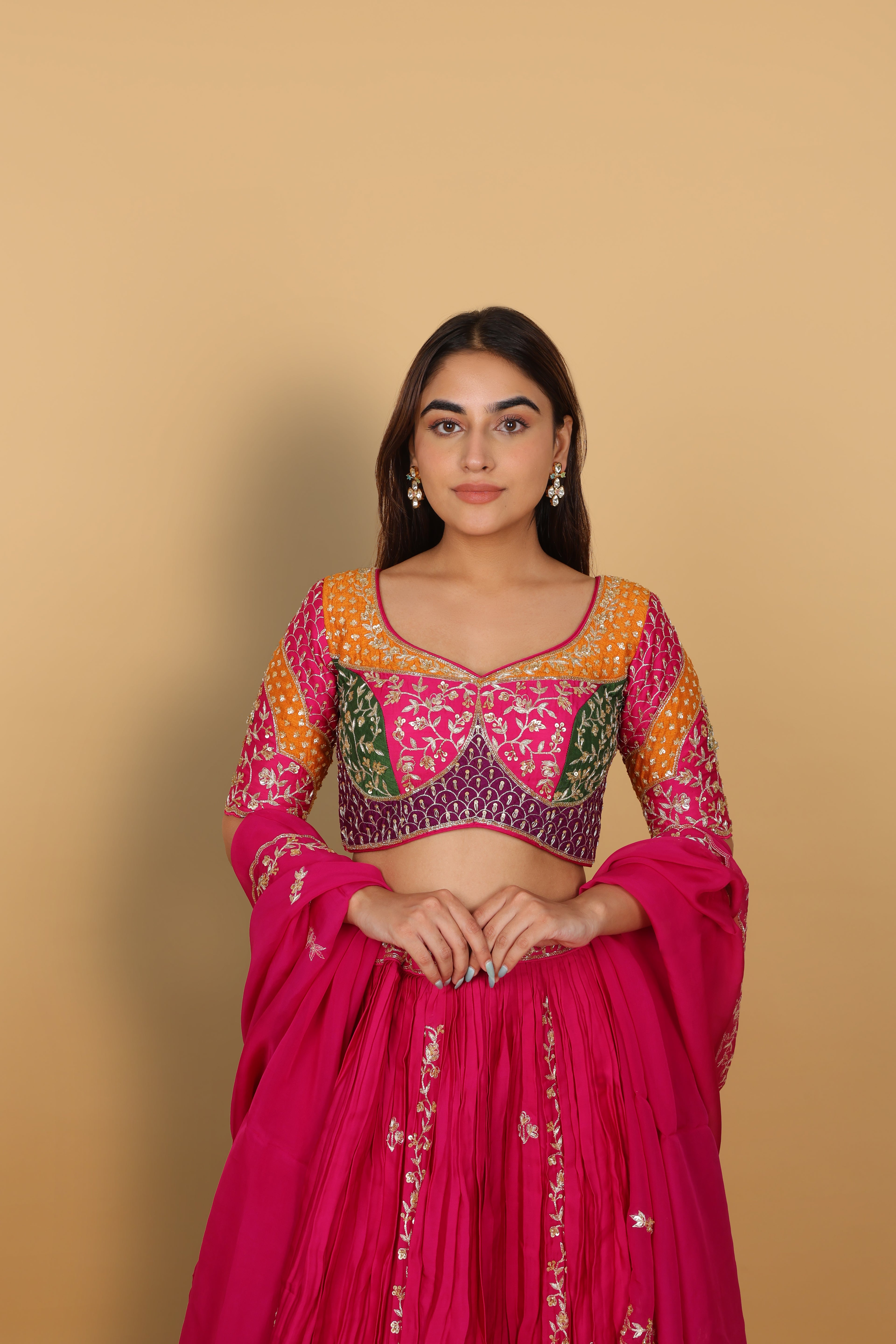 Magenta/Rani lehenga with a heavily worked multicoloured blouse and dupatta
