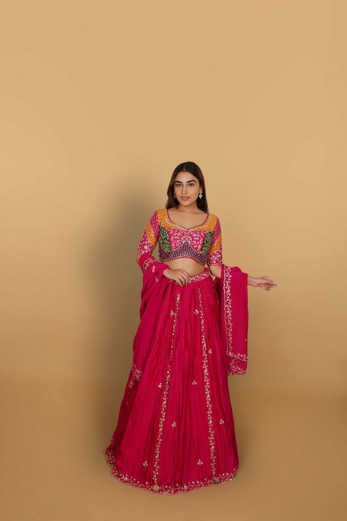 Magenta/Rani lehenga with a heavily worked multicoloured blouse and dupatta