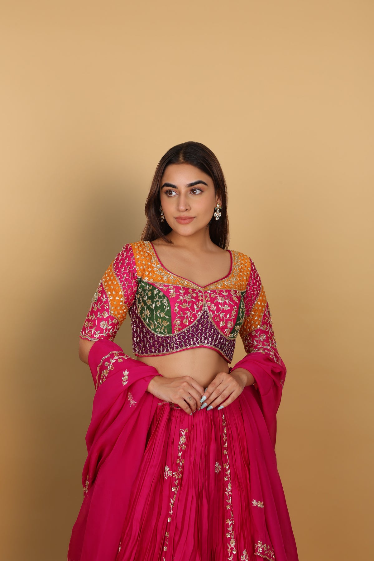 Magenta/Rani lehenga with a heavily worked multicoloured blouse and dupatta