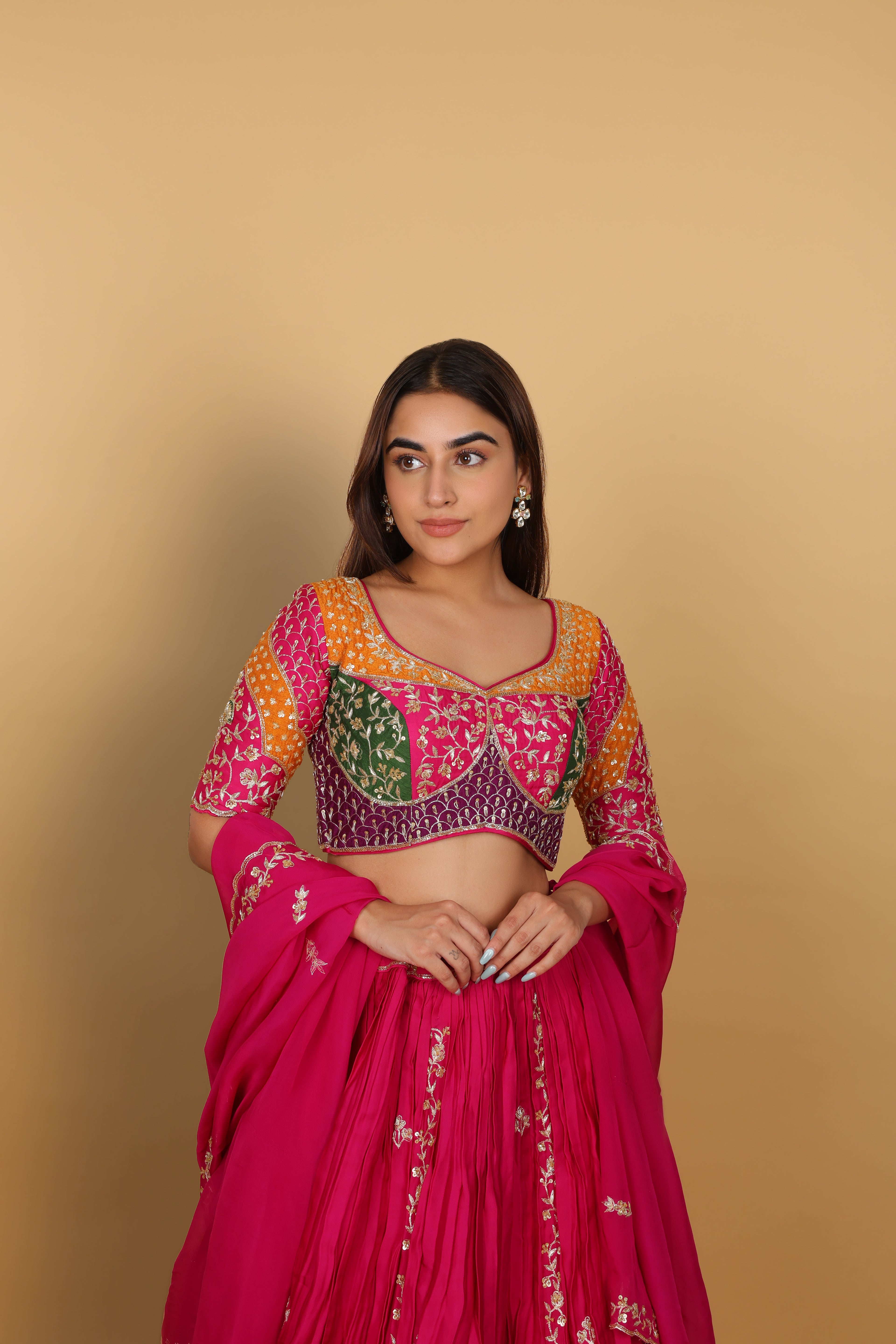 Magenta/Rani lehenga with a heavily worked multicoloured blouse and dupatta