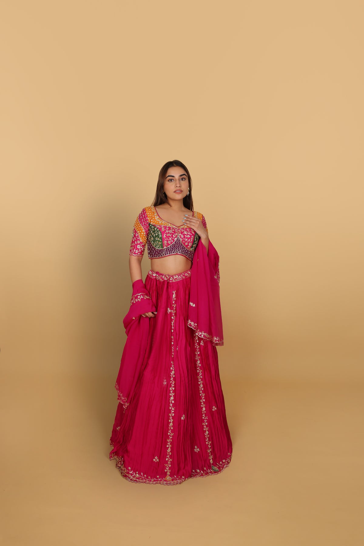 Magenta/Rani lehenga with a heavily worked multicoloured blouse and dupatta